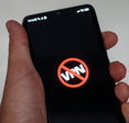 Man holding phone that shows the word "VPN" crossed out because it's been banned.