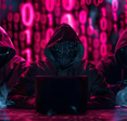 A group of hooded hackers in front of laptops with neon zeros and ones cascading in the background