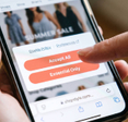 Hand holding smartphone with cookie policy consent popup on screen