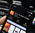 Hand holding cellphone with Suno app download page open.