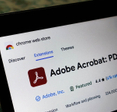 Laptop screen displaying the Adobe Acrobat extension page on the Chrome web store.