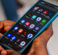 Close-up of a pair hands holding their Android phone looking at a screen of apps