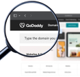 GoDaddy logo on the homepage under a magnifying glass
