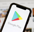 Google Play Store logo displayed on a smartphone screen with a blurred digital marketplace interface in the background.