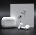 Apple AirPods Pro 2nd generation next to charging case and packaging box on black background.