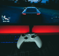 A video game controller sitting in front of a monitor