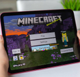 Child holding iPad with Minecraft on screen