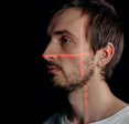 A man with a red crosshair laser over his face.