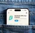 Closeup of back jeans pocket featuring smartphone with Surfshark app market on screen