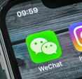 Wechat messenger application icon on Apple iPhone X smartphone screen close-up. 