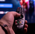 closeup of hand holding an LG smart TV remote