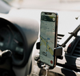A phone open to Google Maps mounted in a car.