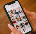 A well-manicured pair of hands holds a phone open to TikTok.
