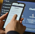 Person using ChatGPT on mobile and laptop