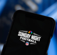 A closeup of a smartphone displaying Sunday Night Football and NBC and NFL emblems