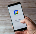 A Mobile phone or cell phone being held showing the Google Calendar app open on screen