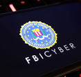 Smartphone screen with logo lettering of FBI Cyber.