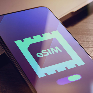 eSIM - Embedded SIM technology concept with smartphone very close lying on a wooden table with esim icon on the screen