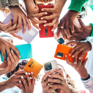 Teens holding cell phones in a circle