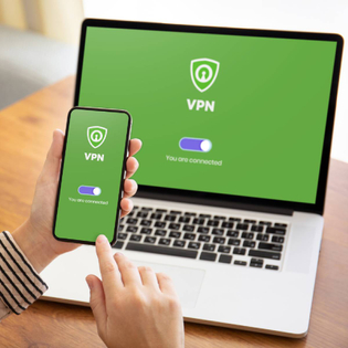 A woman using a vpn on a mobile device and laptop