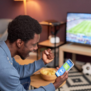 A man cheering while placing NFL bets
