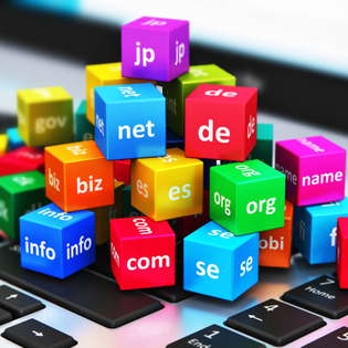 domain name concept of TLDs stacked as colored blocks atop a laptop keyboard