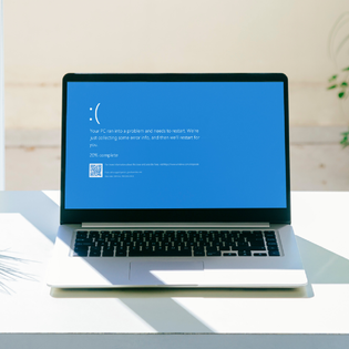 Laptop screen with Microsoft's Blue Screen of Death.