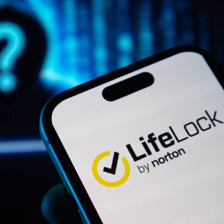 Closeup of LifeLock by Norton logo on smartphone with shady hacker figure in background