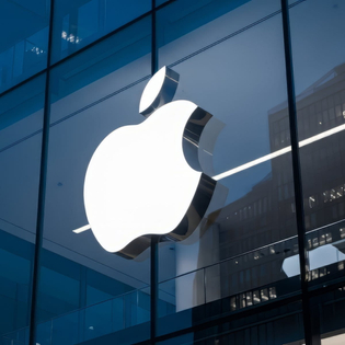 The Apple logo is prominently displayed on the exterior of a modern glass building.