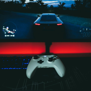 A video game controller sitting in front of a monitor
