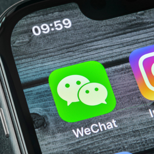 Wechat messenger application icon on Apple iPhone X smartphone screen close-up. 