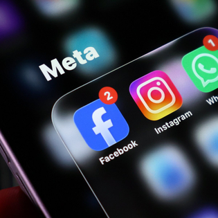 Closeup of a smartphone screen displaying the meta app group folder containing facebook, instagram, and whatsapp icons with notification badges.