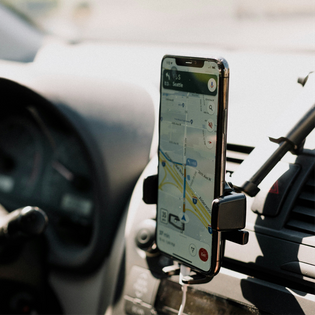A phone open to Google Maps mounted in a car.
