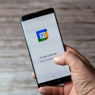 A Mobile phone or cell phone being held showing the Google Calendar app open on screen