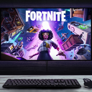 Gaming setup displaying Fortnite artwork on widescreen monitor