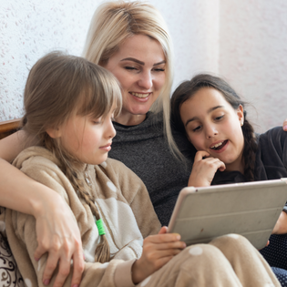 A mom and her two kids use an iPad together.