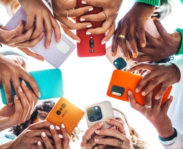 Teens holding cell phones in a circle