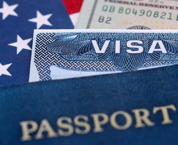 A picture of a visa and passport overtop American flag and dollar bill