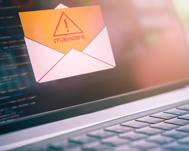 A close-up photo of a laptop with an open envelope icon and a yellow document that says malware coming out of it