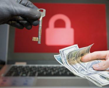 A laptop with a locked screen in the background and a hacker offering a key to unlock encrypted data for money in the foreground.