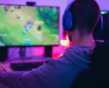 A young gamer playing online video games while streaming on social media.