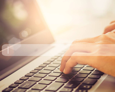 A pair of hands typing on a laptop with an abstract search bar in the foreground.
