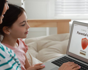 Mom installing parental control on laptop at home.