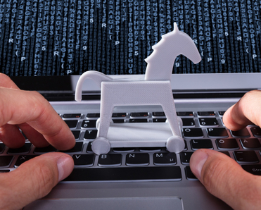 Person with Trojan horse icon on laptop affected by virus.