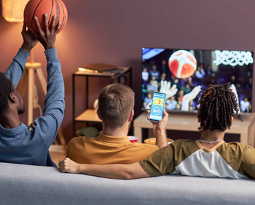Back view of a group of friends watching basketball match at home