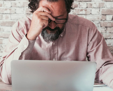 Man working on his laptop looking stressed