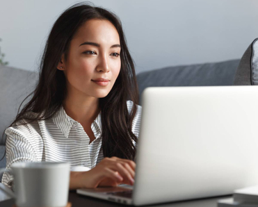 A young woman using her laptop in her living room.