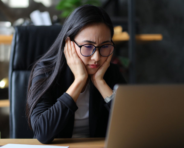 Woman looking at laptop worried