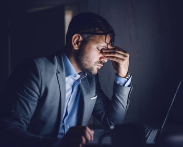 A stressed businessman sitting in front of his laptop