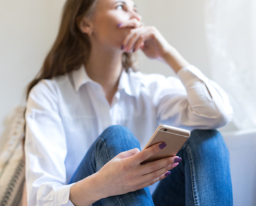 Woman looking concerned holding her phone